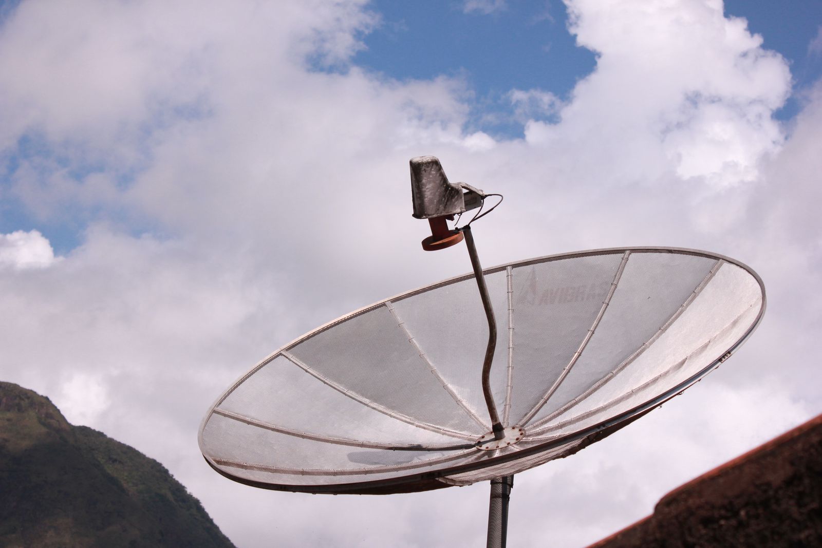 A satellite dish aligned against a clear blue sky, ready for signal testing