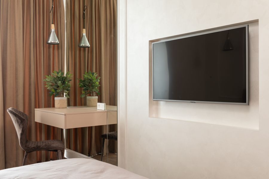 A hotel room with a wall-mounted television