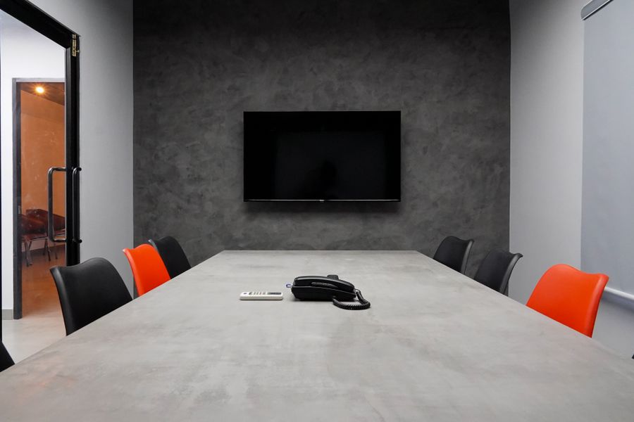 A boardroom with a large wall-mounted screen