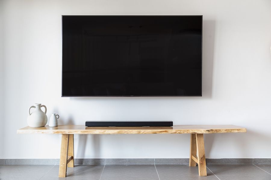 A flat-screen TV wall mounted above a wooden console